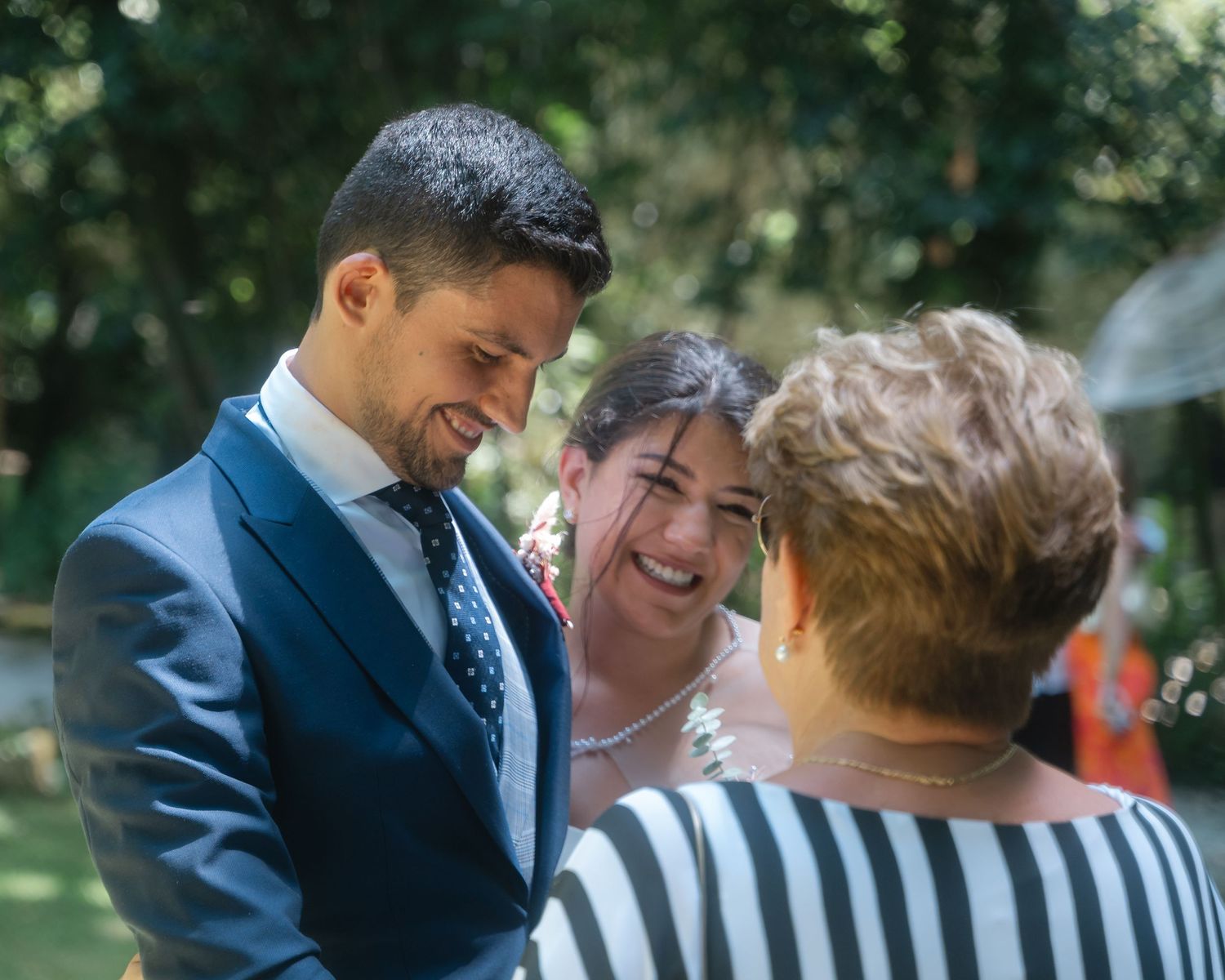 Joyful celebration at an outdoor wedding with guests sharing special moments in a garden setting.