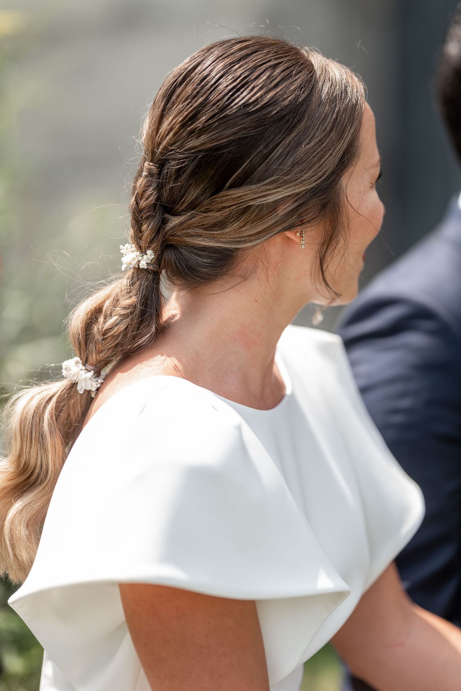Close-up details of a white wedding dress with elegant cap sleeves and structured neckline.
