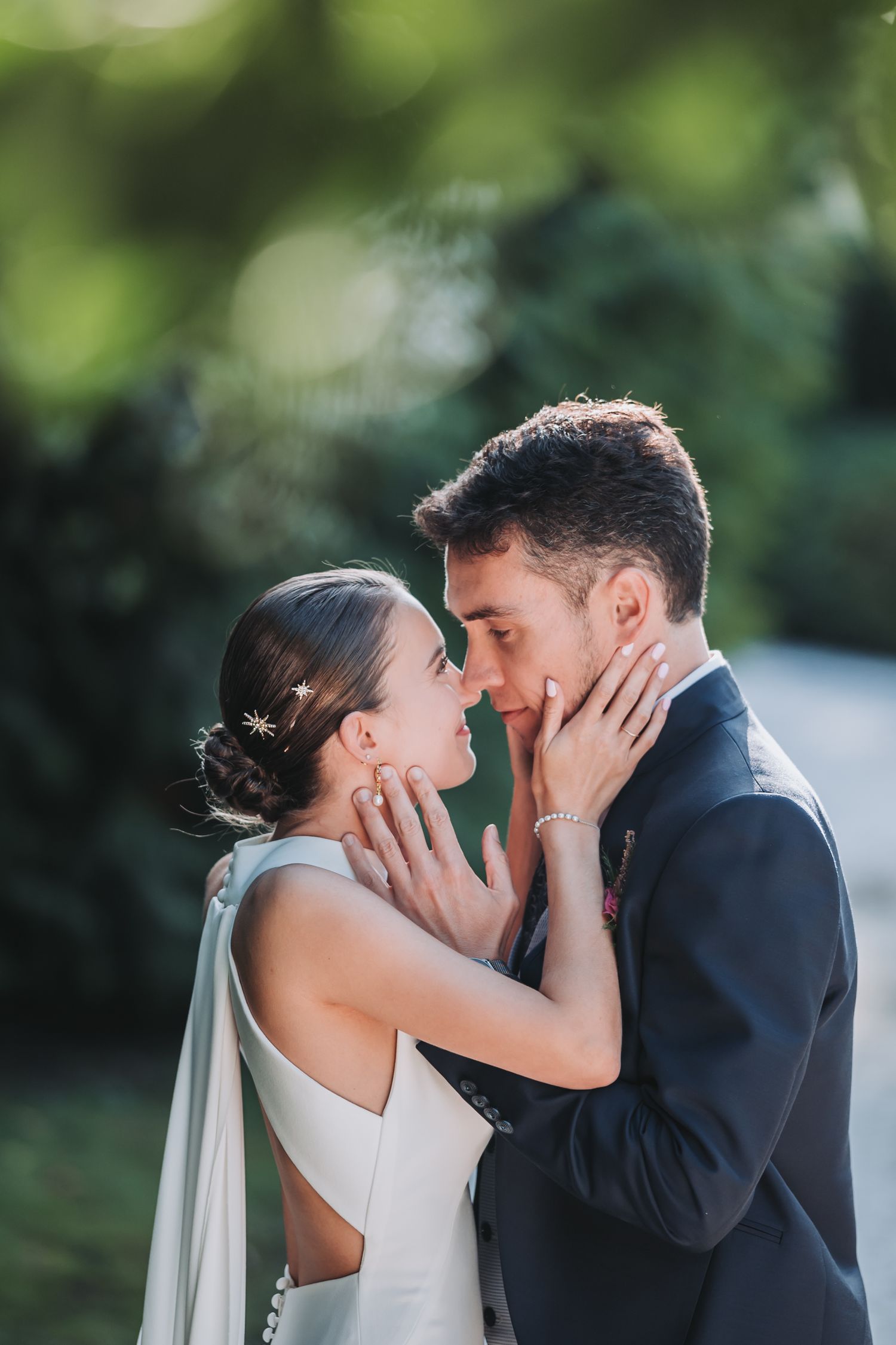 Tender wedding moment captured in a garden setting with soft natural lighting.