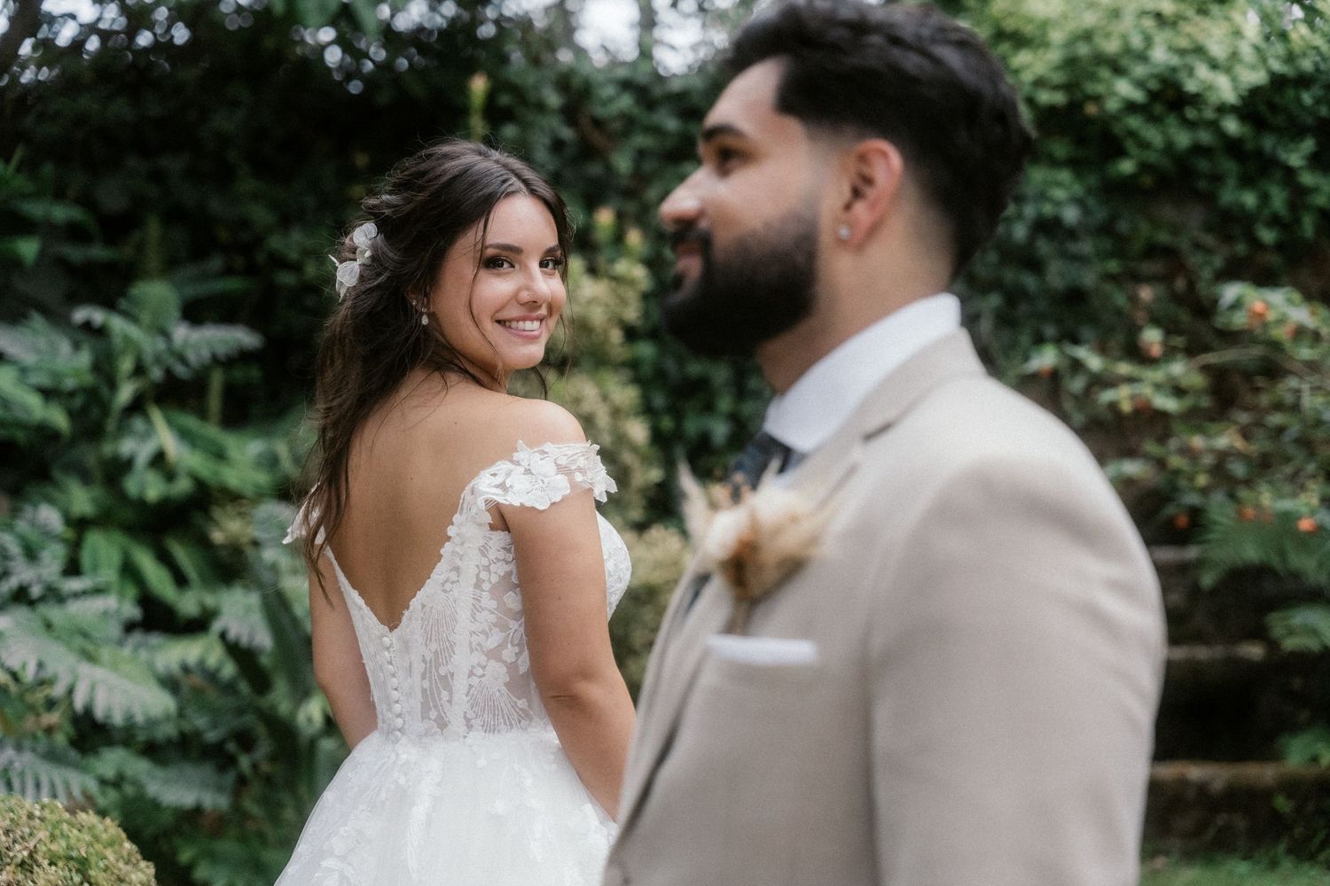 A couple shares romantic moments in a lush garden setting during their wedding celebration.