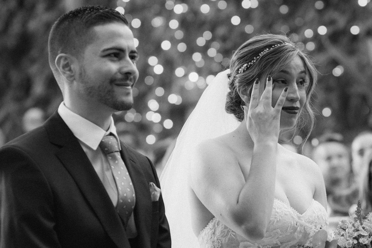 Newlyweds sharing a romantic moment during their first dance under twinkling lights.
