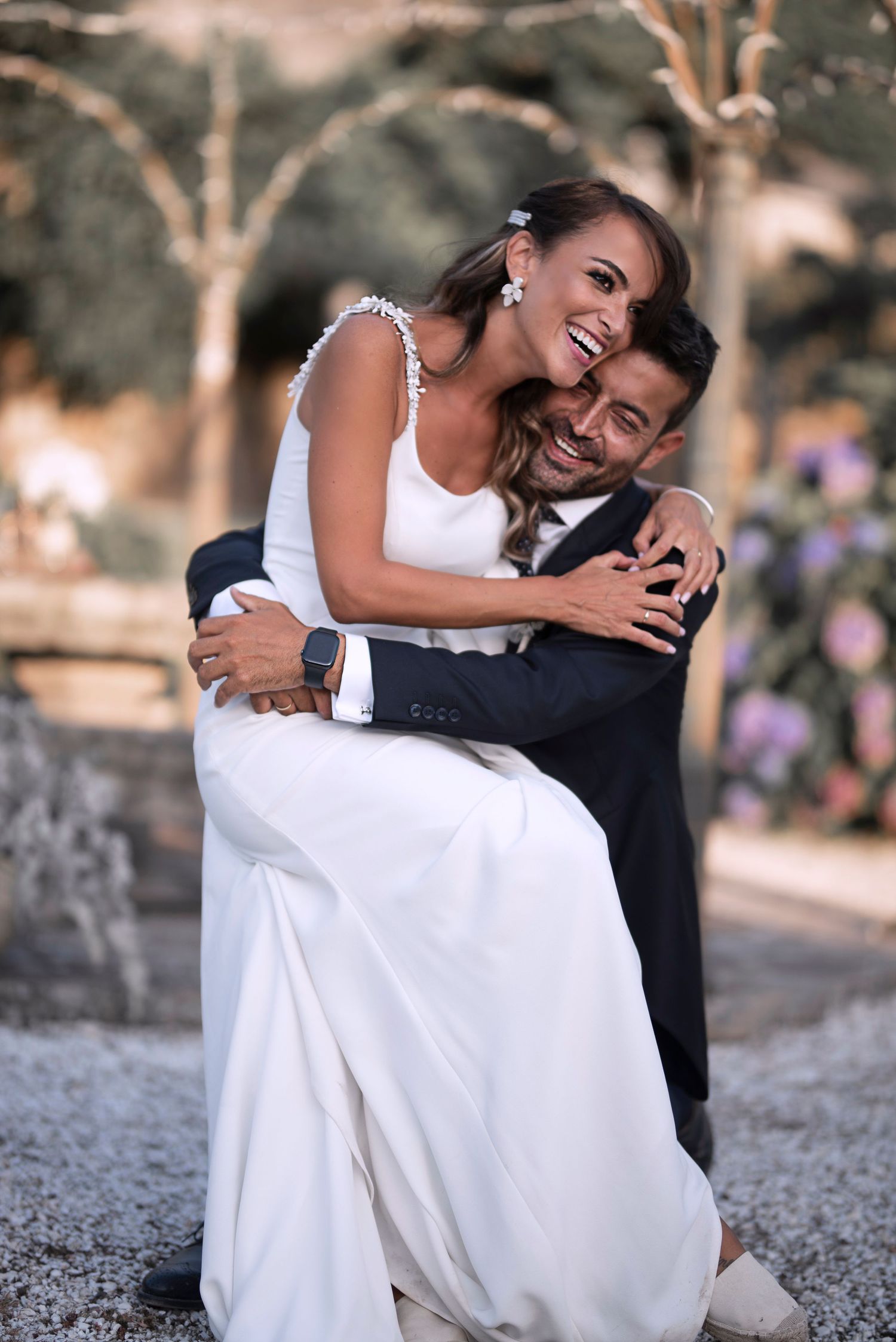 A series of romantic outdoor photos showing a couple in wedding attire embracing on a gravel path.