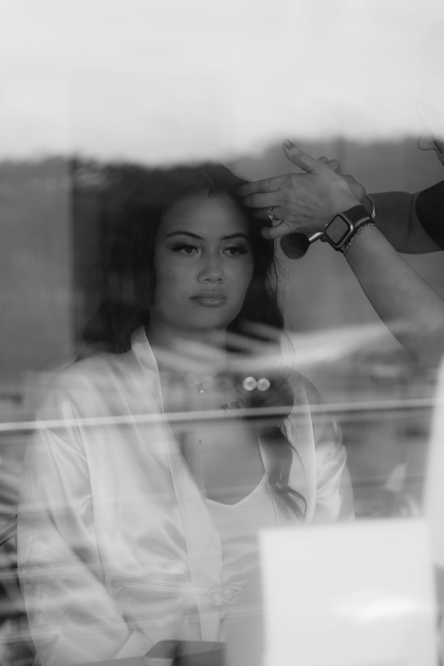 Black and white artistic photo of wedding day preparations with soft focus and dreamy lighting.