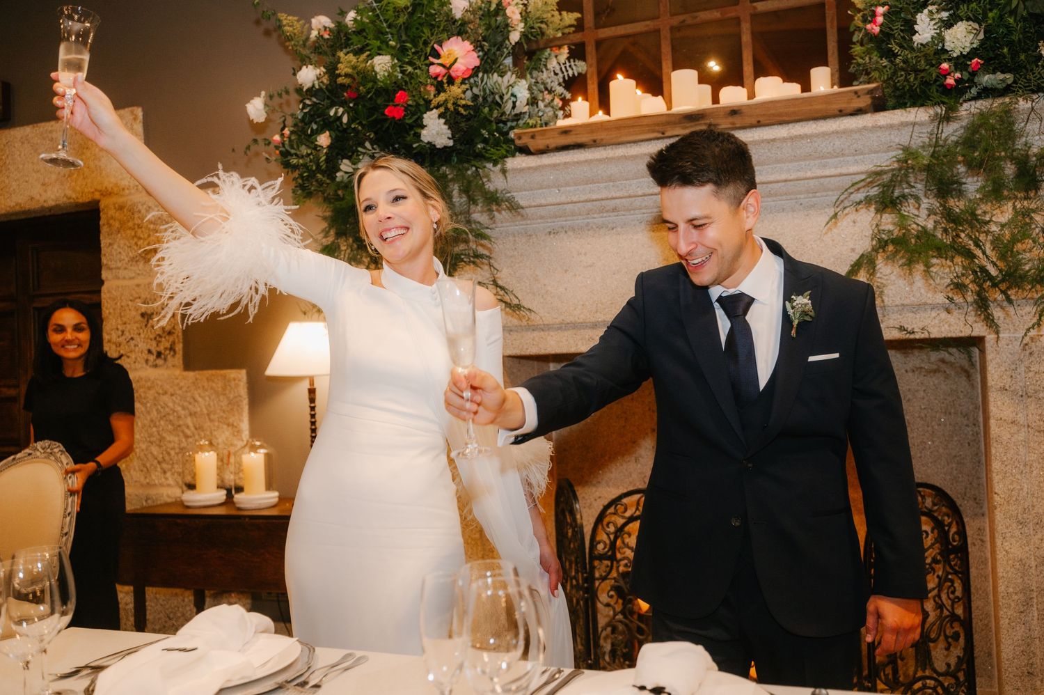Elegant wedding reception venue with floral arrangements, white decor and warm lighting creating a romantic atmosphere.