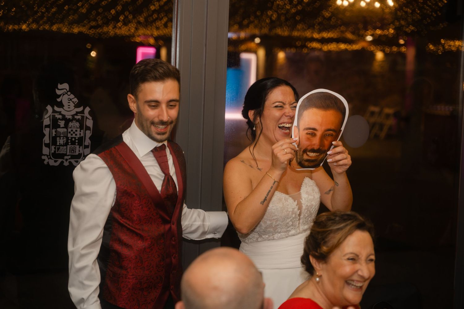 Wedding reception party with guests dancing and celebrating under warm lighting.