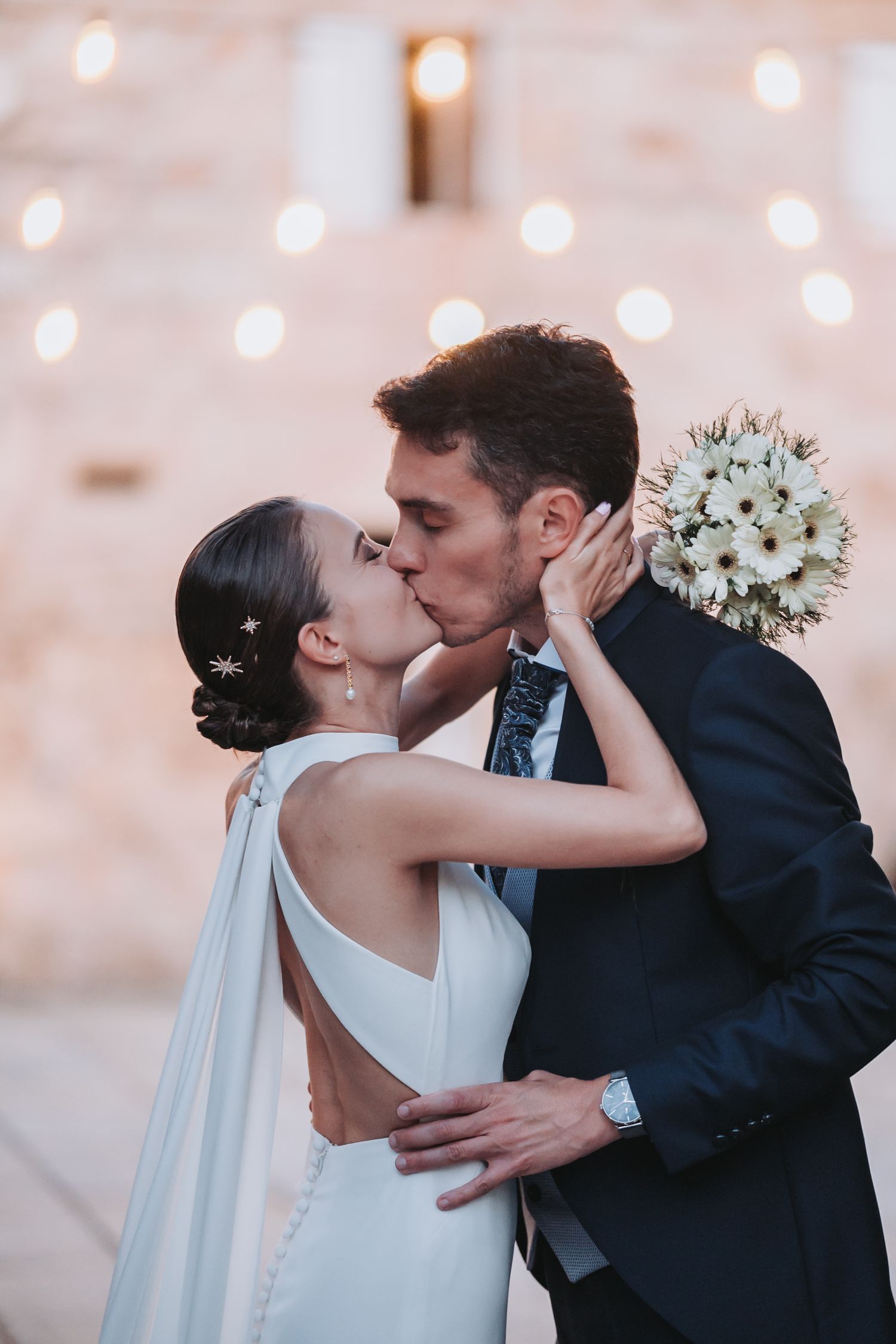 A romantic wedding kiss sequence captured in soft lighting with white floral details.
