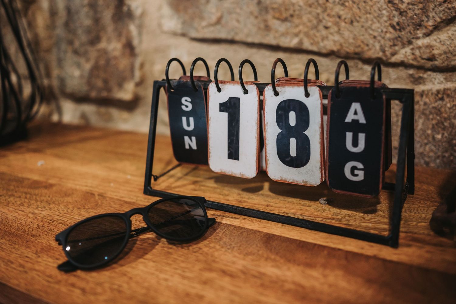 Black scoreboard numbers and letters arranged on a wooden surface for event display.