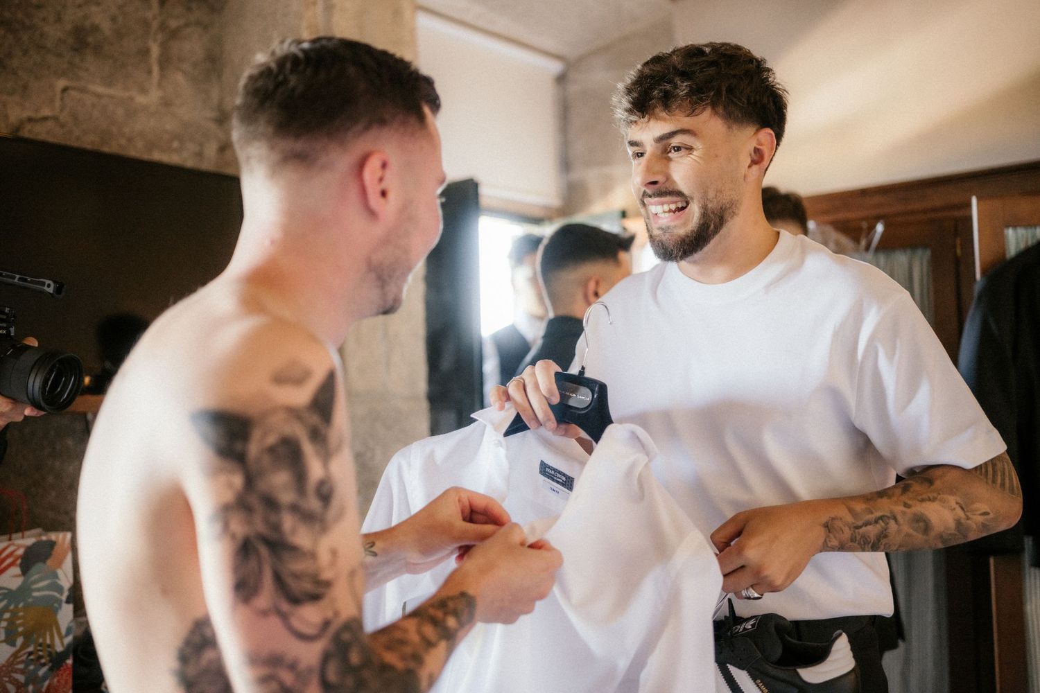 Groomsmen help each other get ready by adjusting ties and buttons in a pre-wedding preparation sequence.