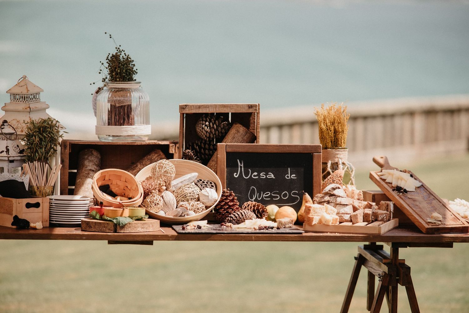 Rustic wooden table settings with vintage decor and floral arrangements at an outdoor event.