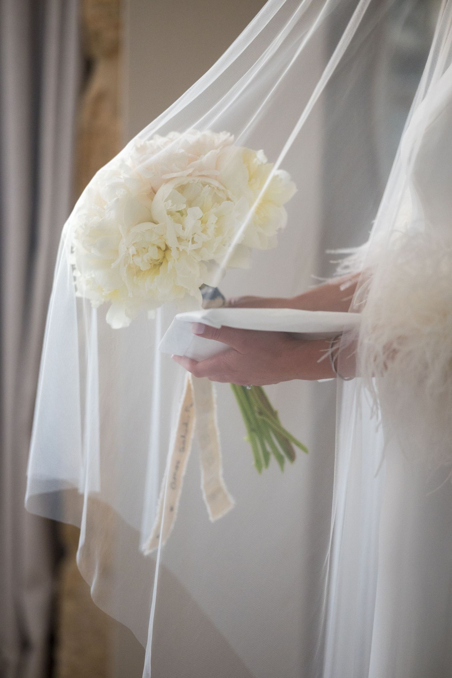 Close-up of white bridal veil with yellow flower bouquet details.