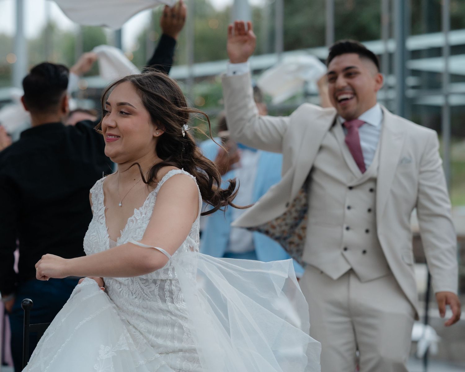 Wedding celebration on a dance floor with joyful dancing and celebration in formal wedding attire.