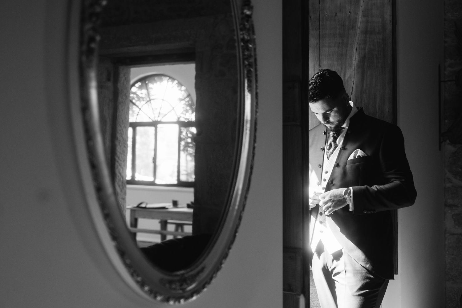 Series of dramatic black and white interior shots featuring window light and oval mirror reflections.