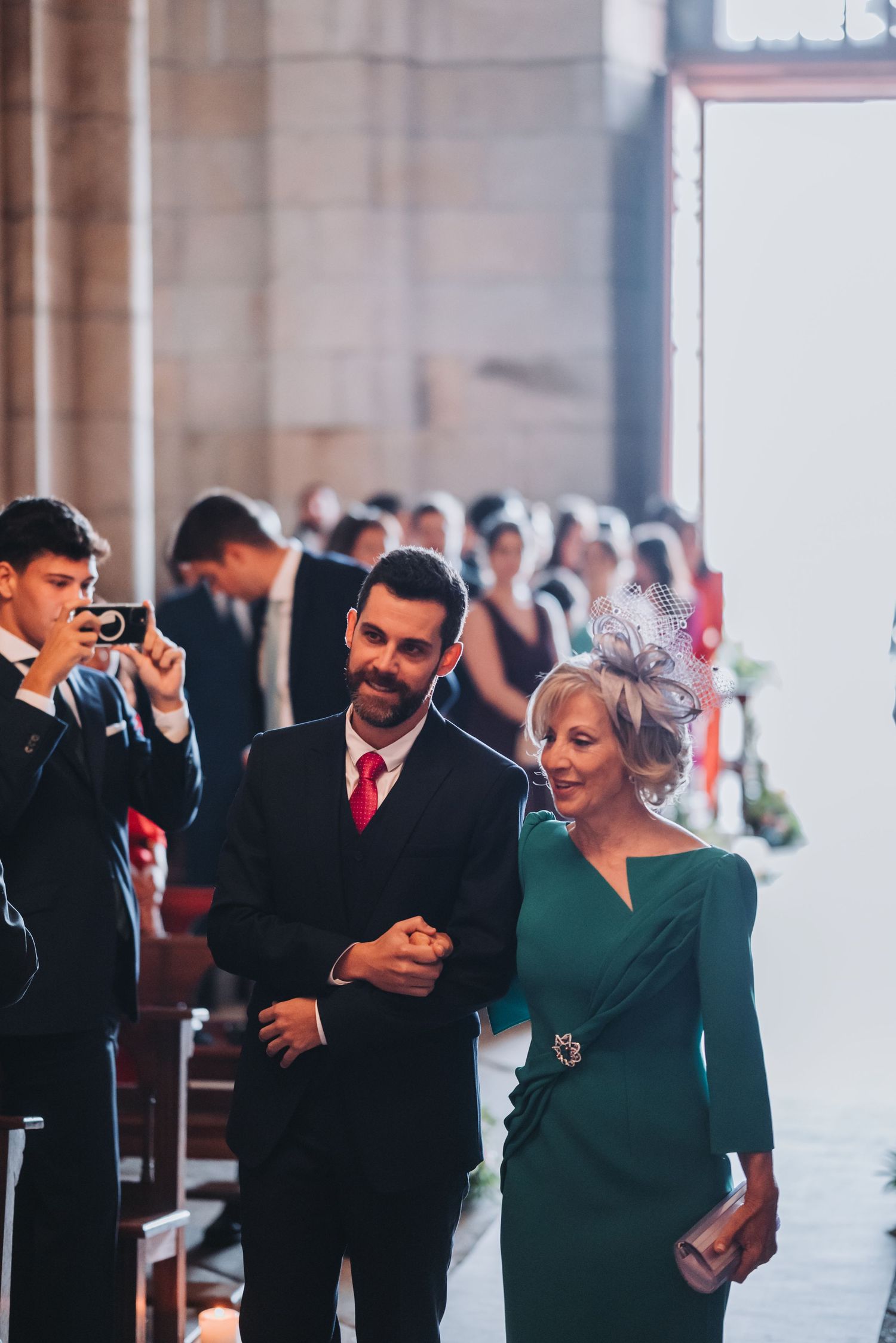 Couple dancing together at an elegant indoor venue with stone columns and formal attire.
