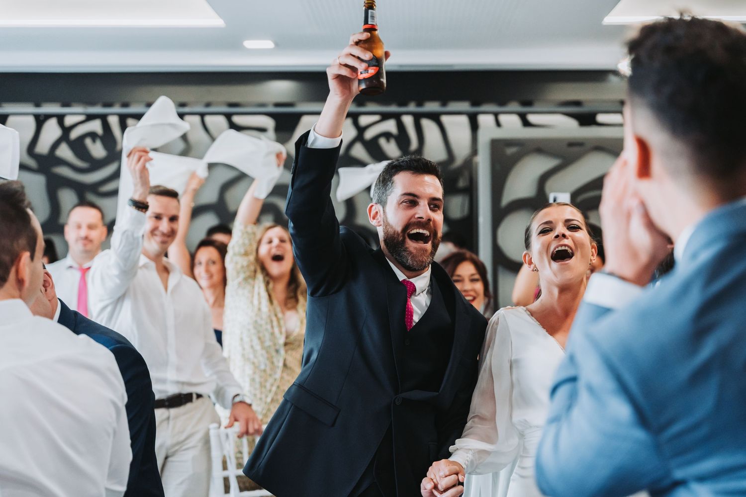 Wedding guests celebrate and dance together during a joyful reception celebration.
