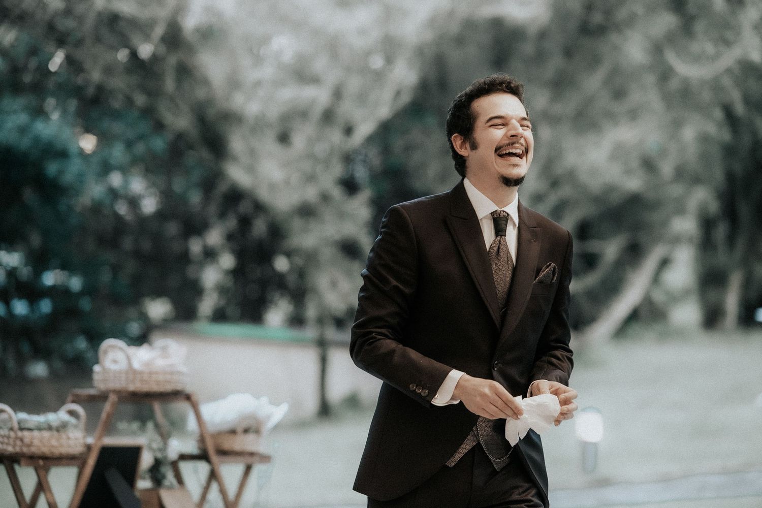 A series of candid black and white portraits showing joyful expressions and laughter in an outdoor setting.
