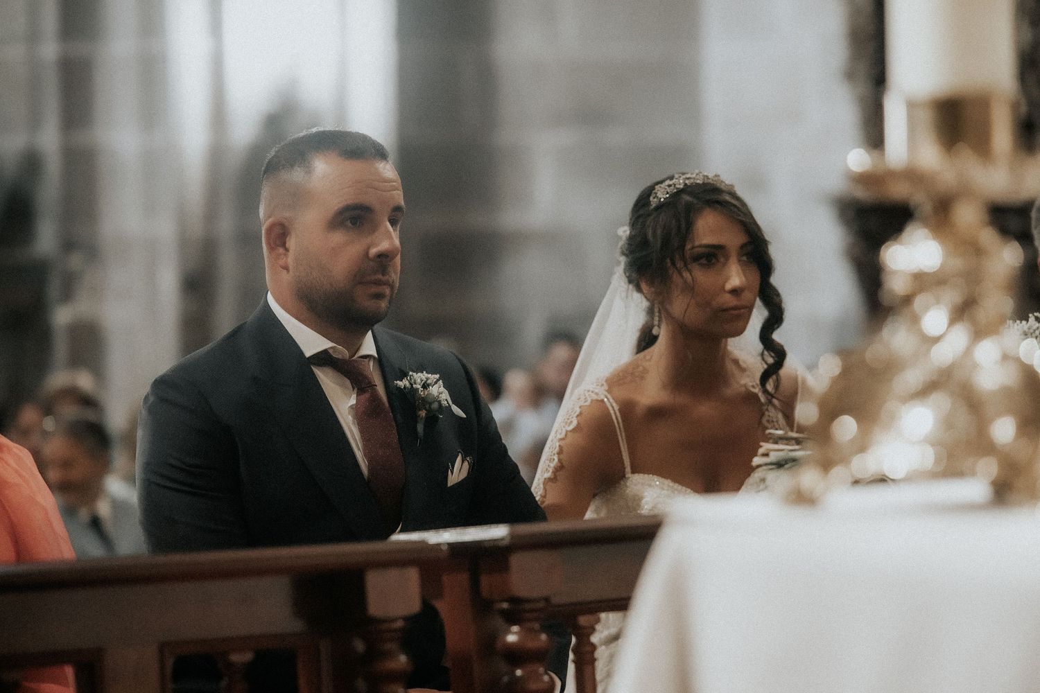 Bride and groom share an intimate moment during their wedding ceremony in an elegant indoor venue.