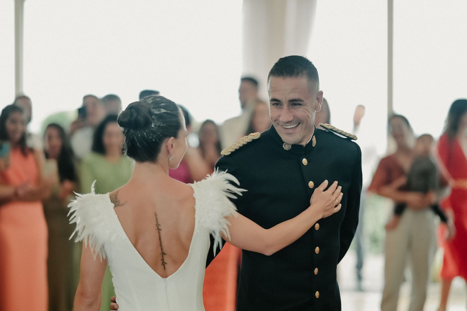A couple dancing together during a romantic wedding reception on a dance floor surrounded by guests.