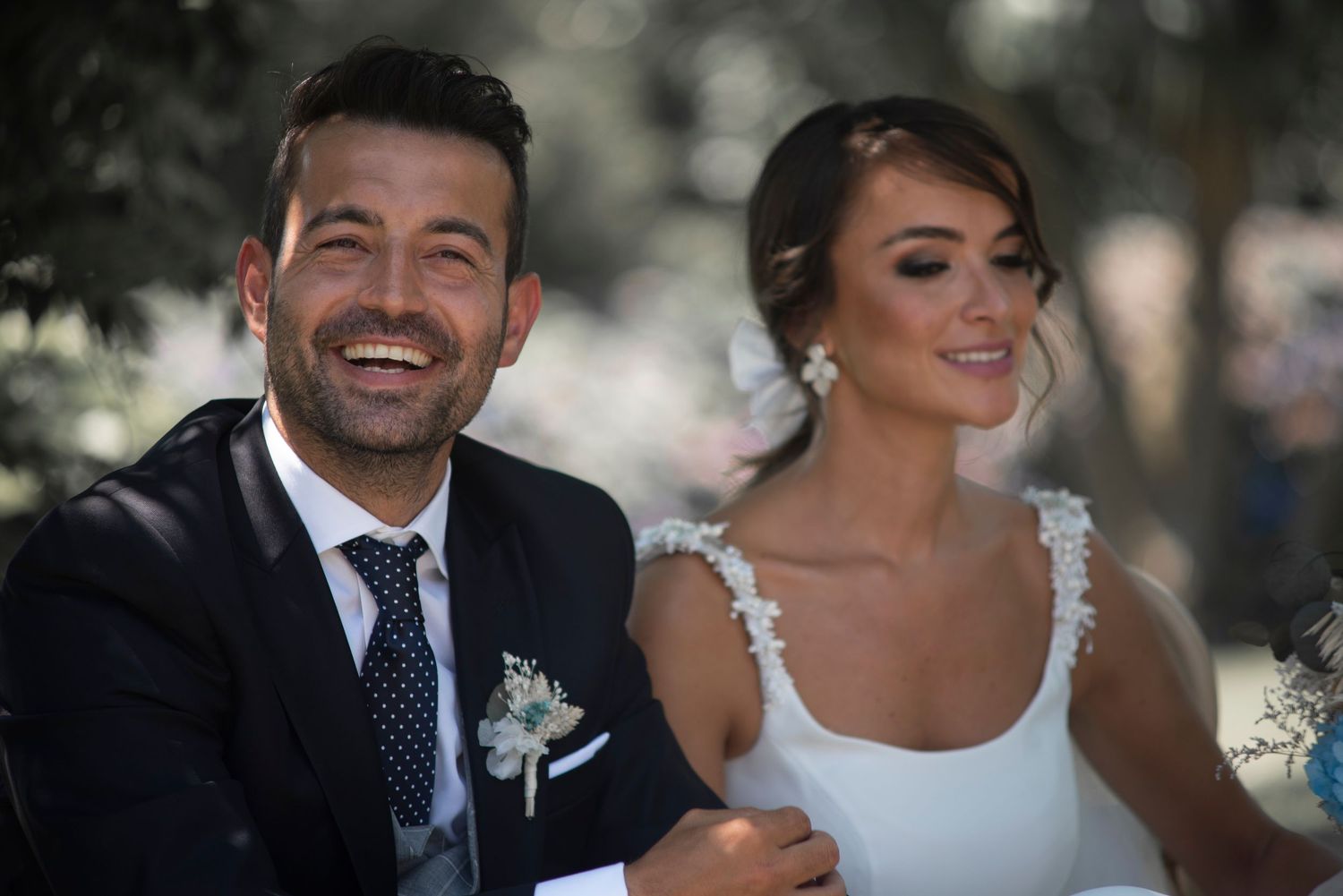 A bride and groom share intimate moments during their outdoor wedding celebration.