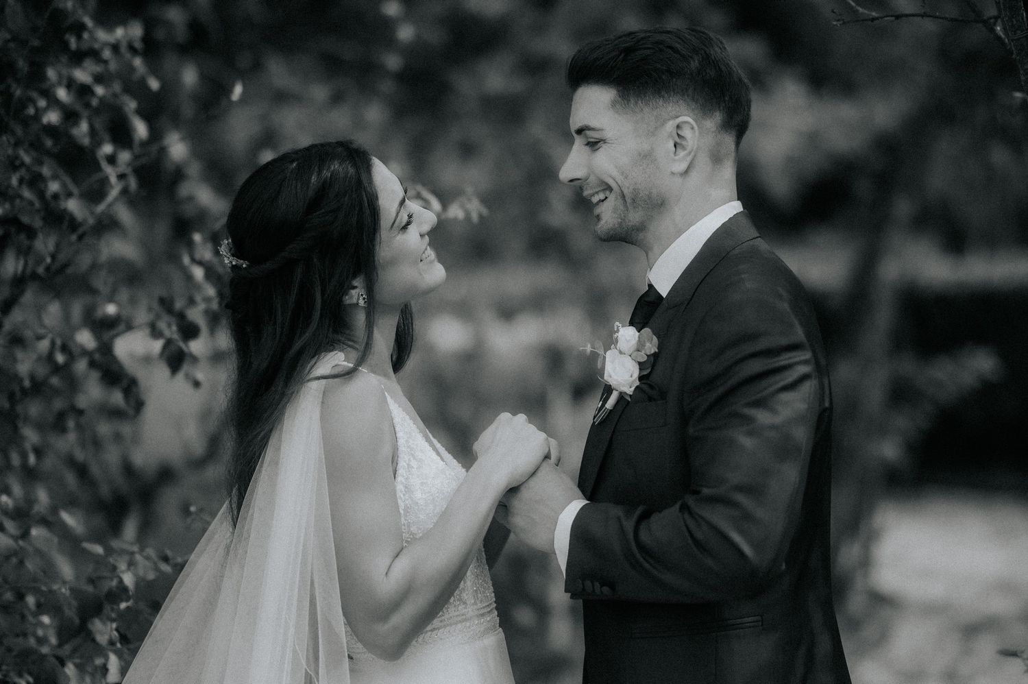 Black and white wedding photos showing romantic moments between a couple in an outdoor garden setting.