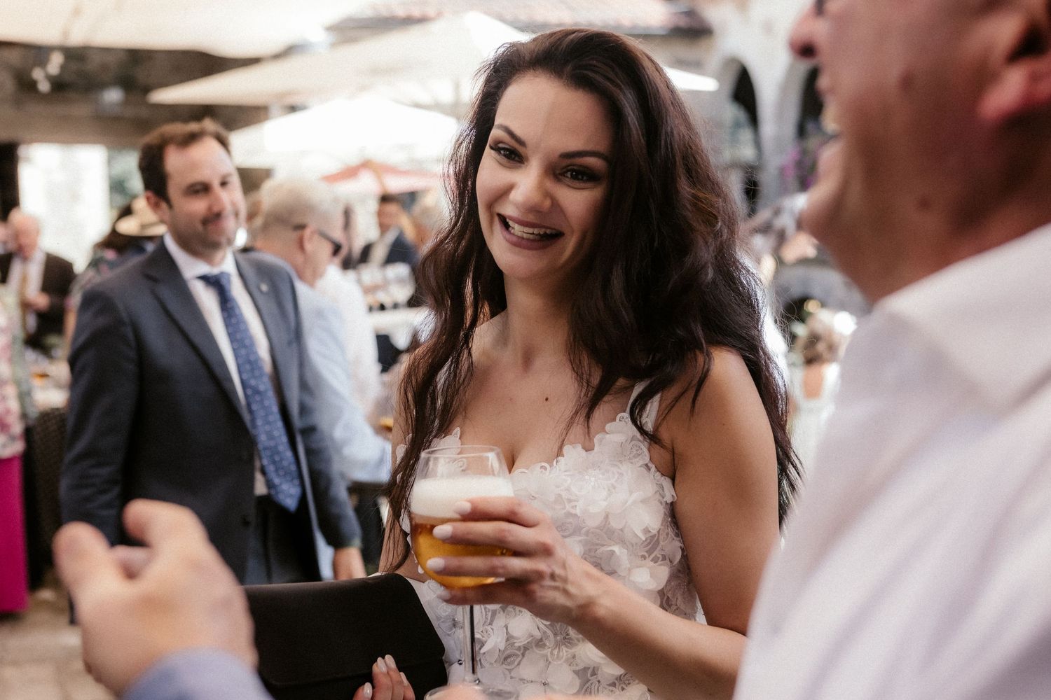 Wedding guests enjoying drinks and conversation during an outdoor reception celebration.