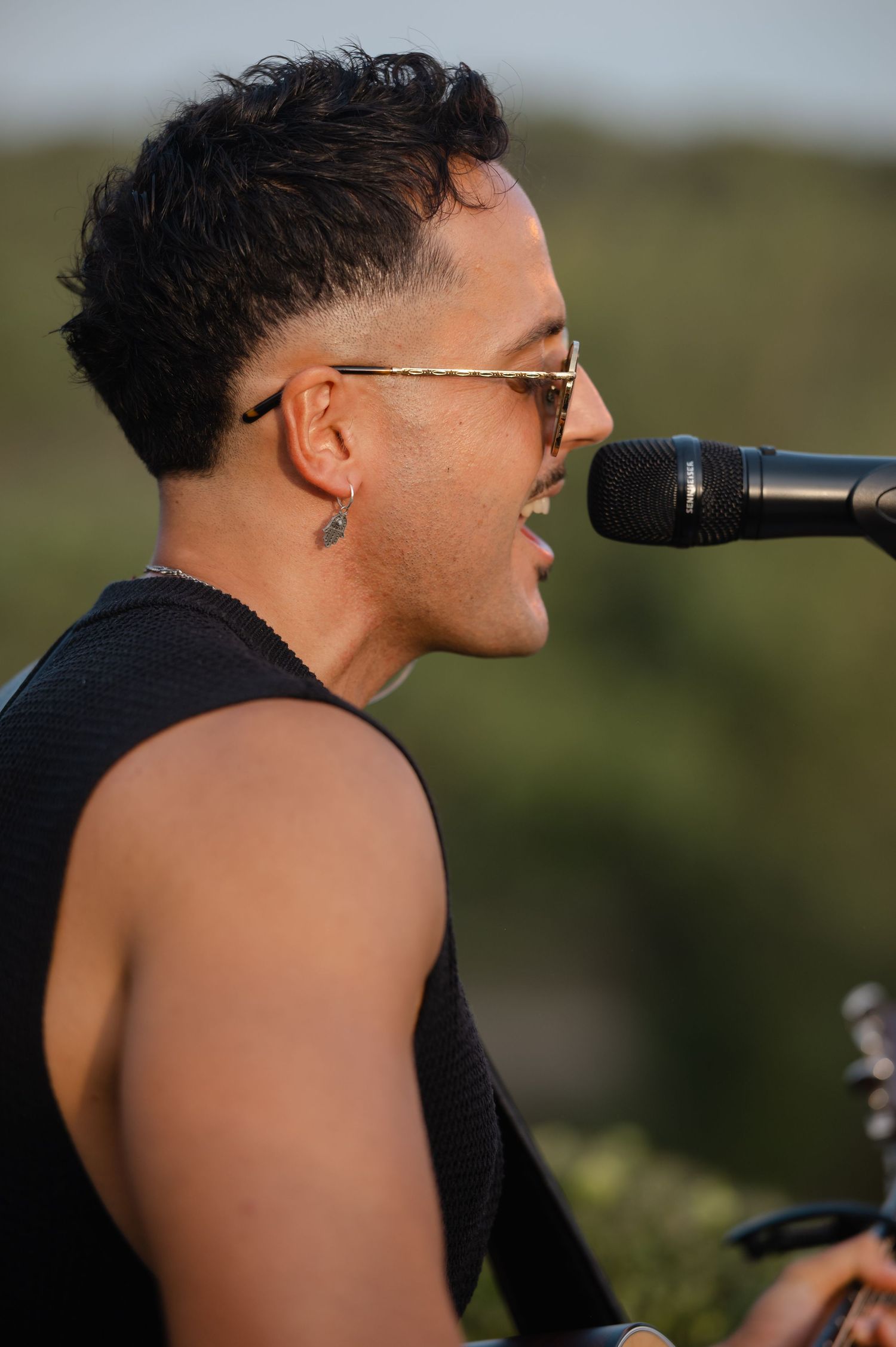 Close-up profile view of someone wearing glasses against a blurred natural background.
