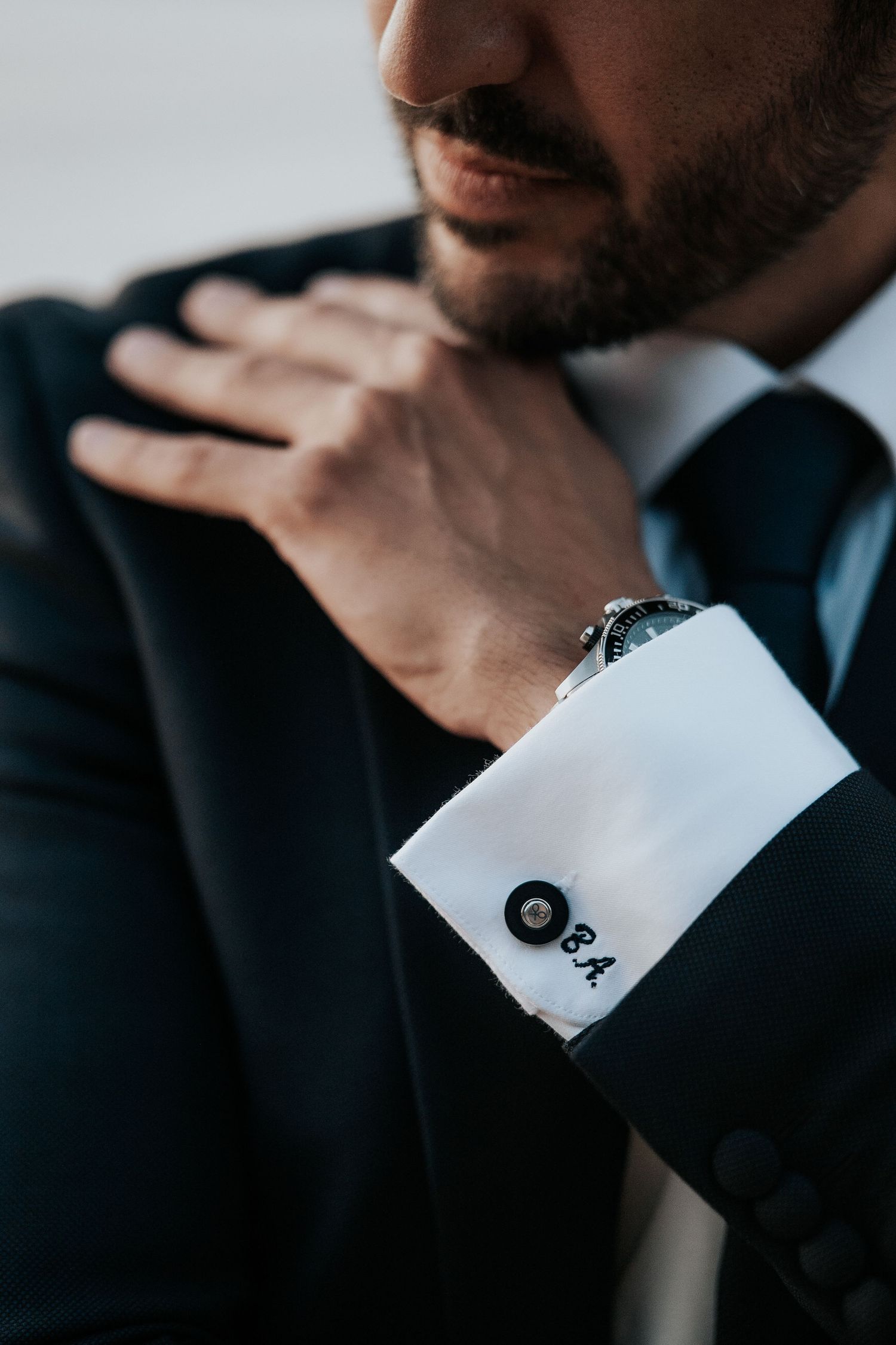 Close-up details of a groom's formal attire showing crisp cuffs and elegant watch.