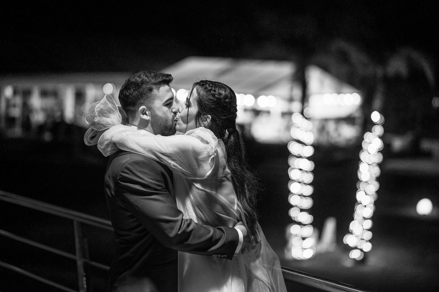 Monochrome image of couples dancing and twirling on a dimly lit dance floor during an evening celebration.