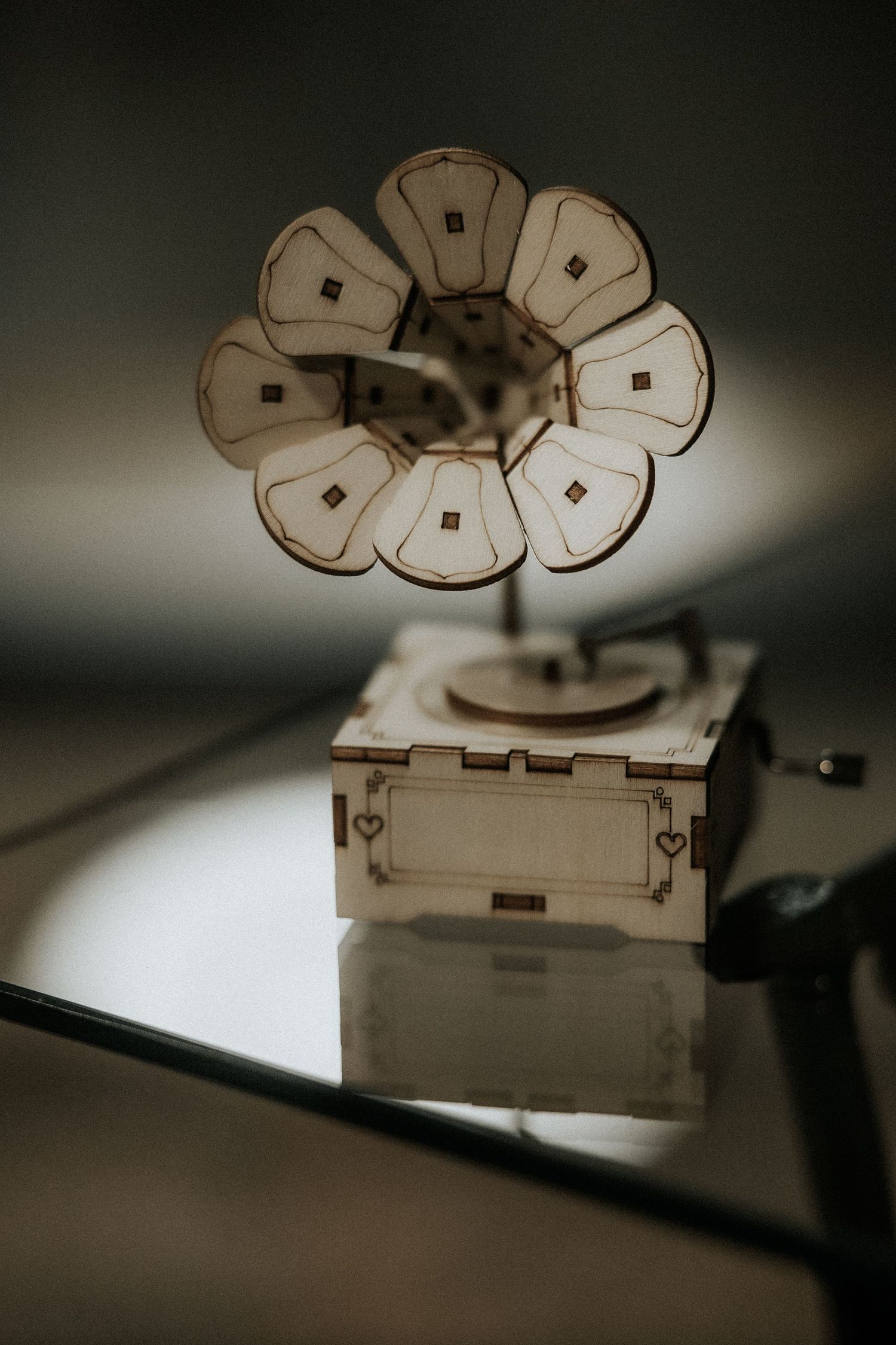 A vintage-style wooden phonograph with a flower-shaped horn photographed in moody sepia tones.