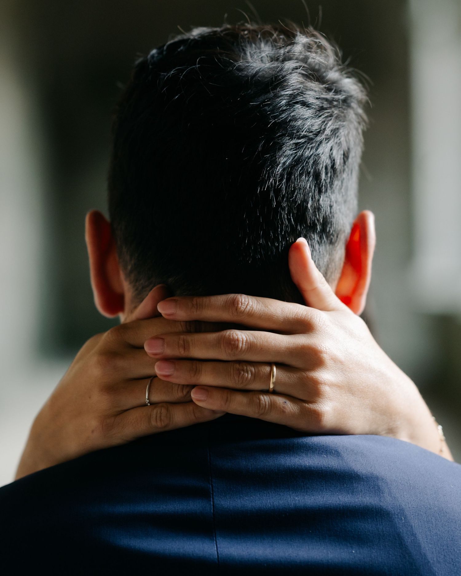 Back of a person's head wearing a navy shirt shown in a series of similar poses against a blurred background.