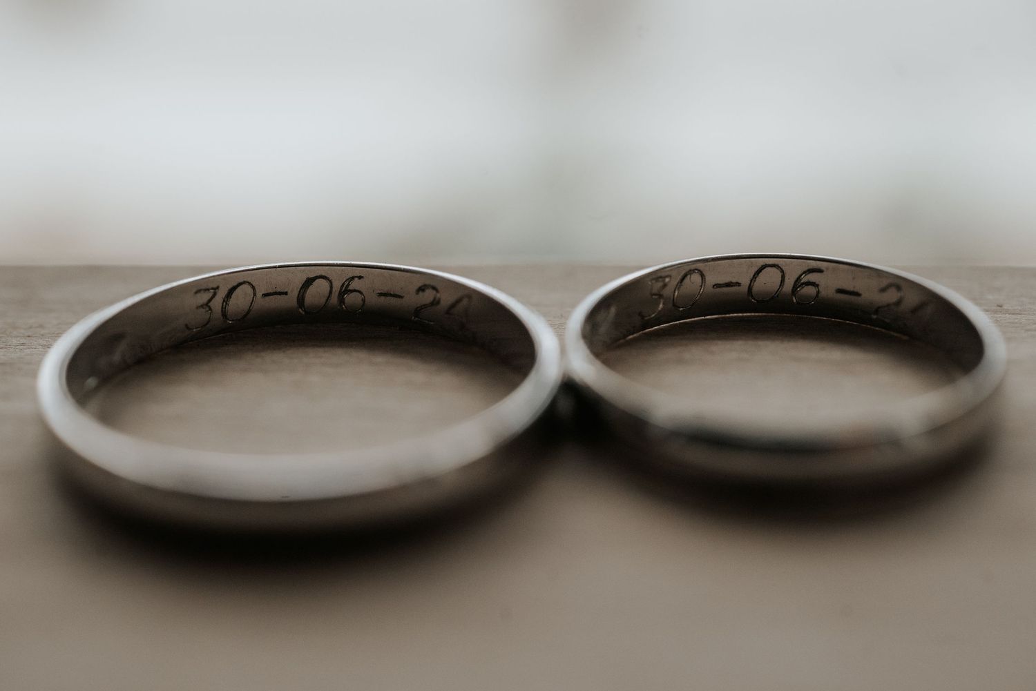 Seven identical wedding rings are arranged in a row showing different angles against a light gray background.