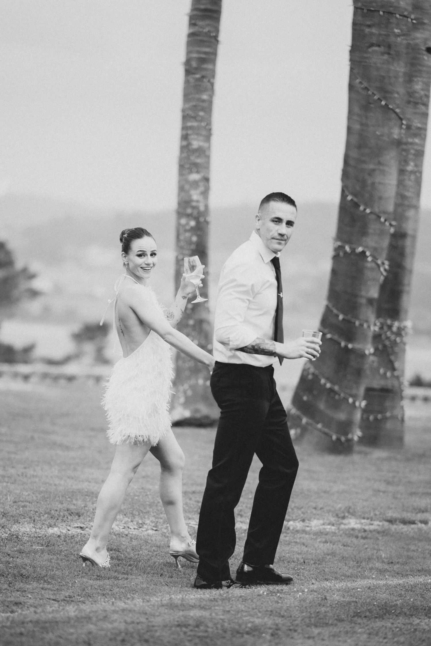 A romantic sequence of black and white photos showing a couple playfully posing among palm trees.