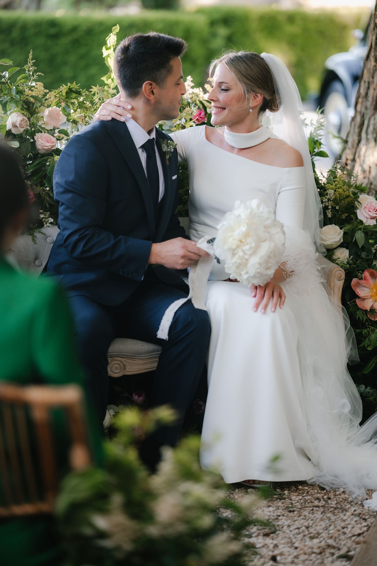 Romantic wedding portraits captured in a garden setting with elegant floral arrangements.