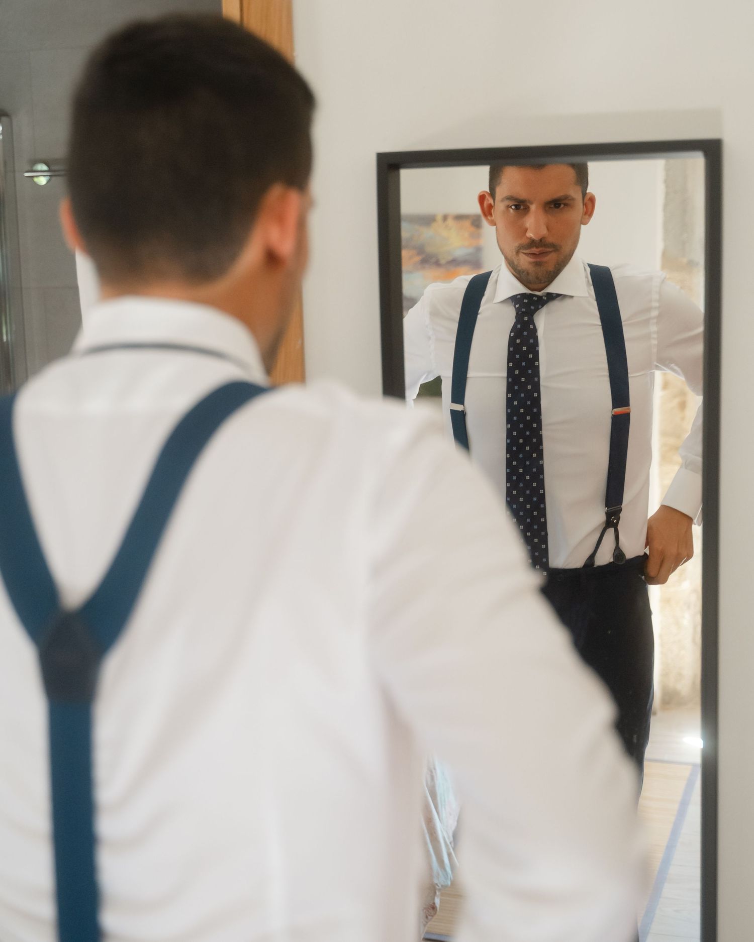 A sequence showing formal wear preparation with focus on ties and suspenders in a bright room.