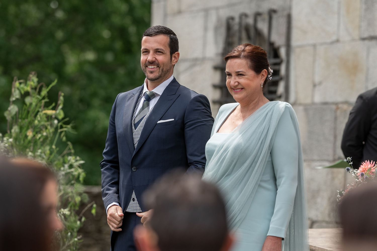 A couple in formal attire share a joyful moment while walking together outdoors.