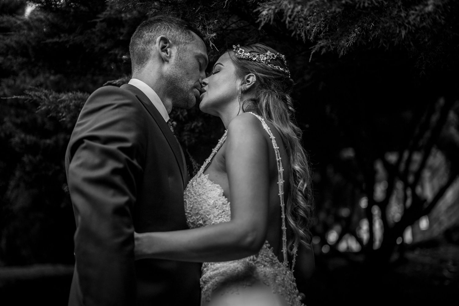 Romantic black and white wedding photos showing intimate moments between newlyweds in an outdoor garden setting.
