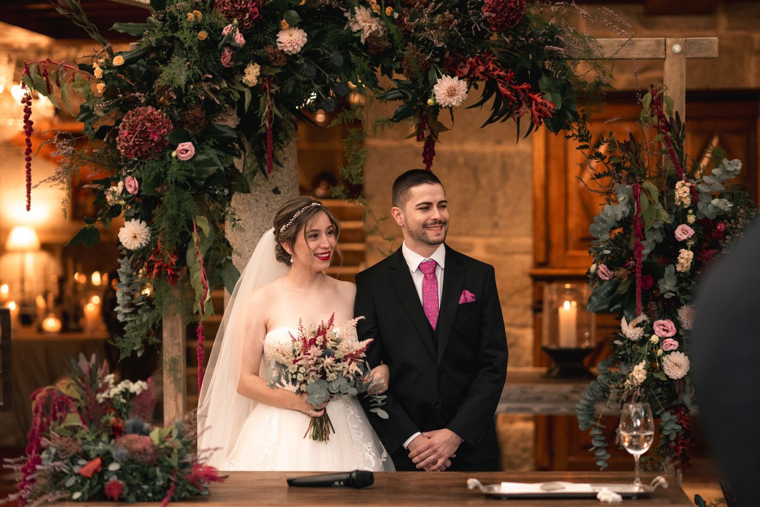 Rustic wedding ceremony venue decorated with floral arrangements and warm lighting.