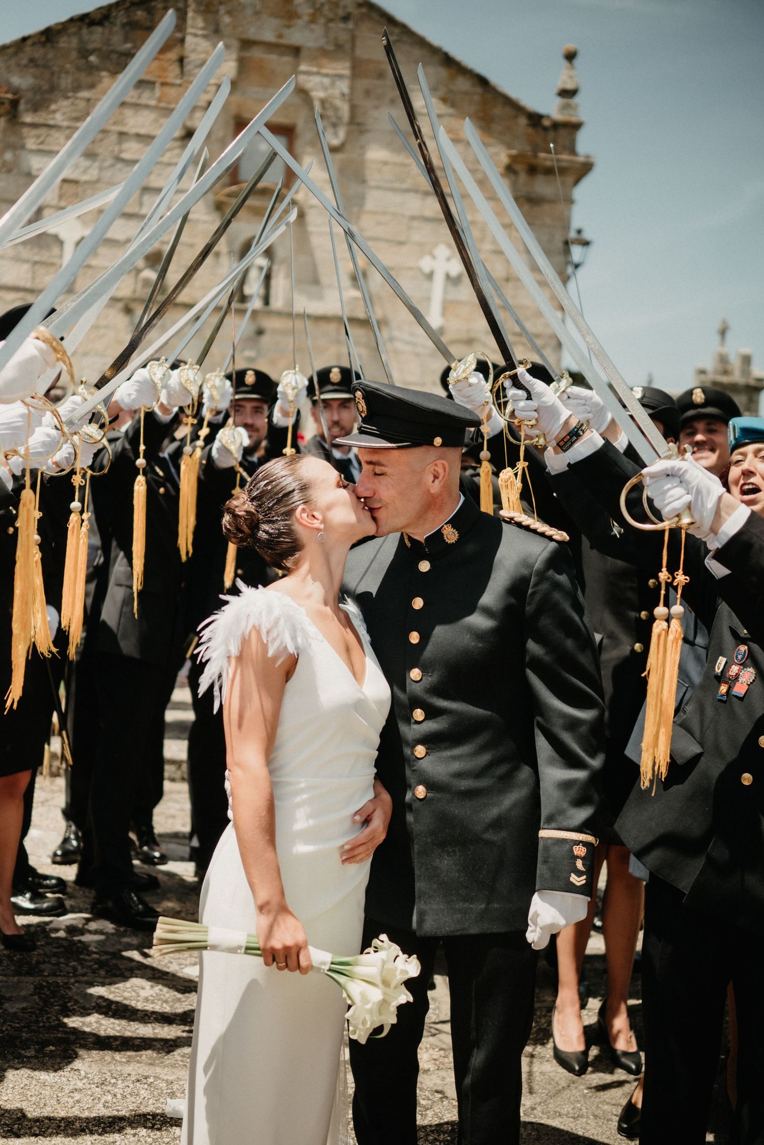 Military wedding ceremony with sword arch salute outside historic building.