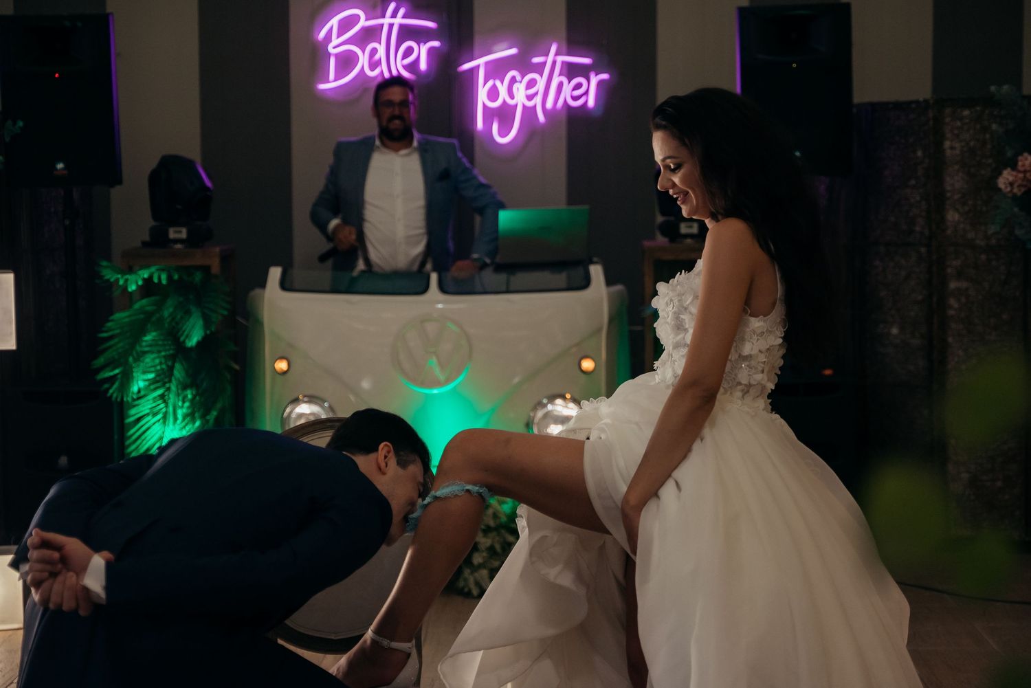 Neon 'Better Together' sign glowing in pink against dark wedding reception backdrop.
