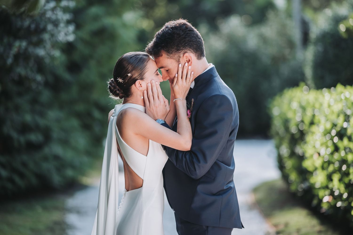 A romantic wedding couple shares intimate moments in a lush garden setting during their outdoor photo session.