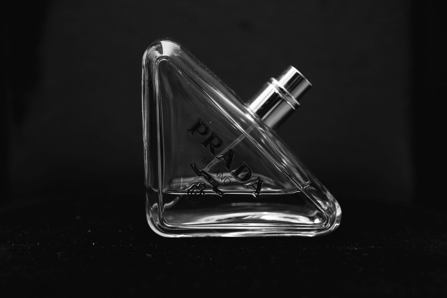Close-up details of elegant perfume bottles in black and white.