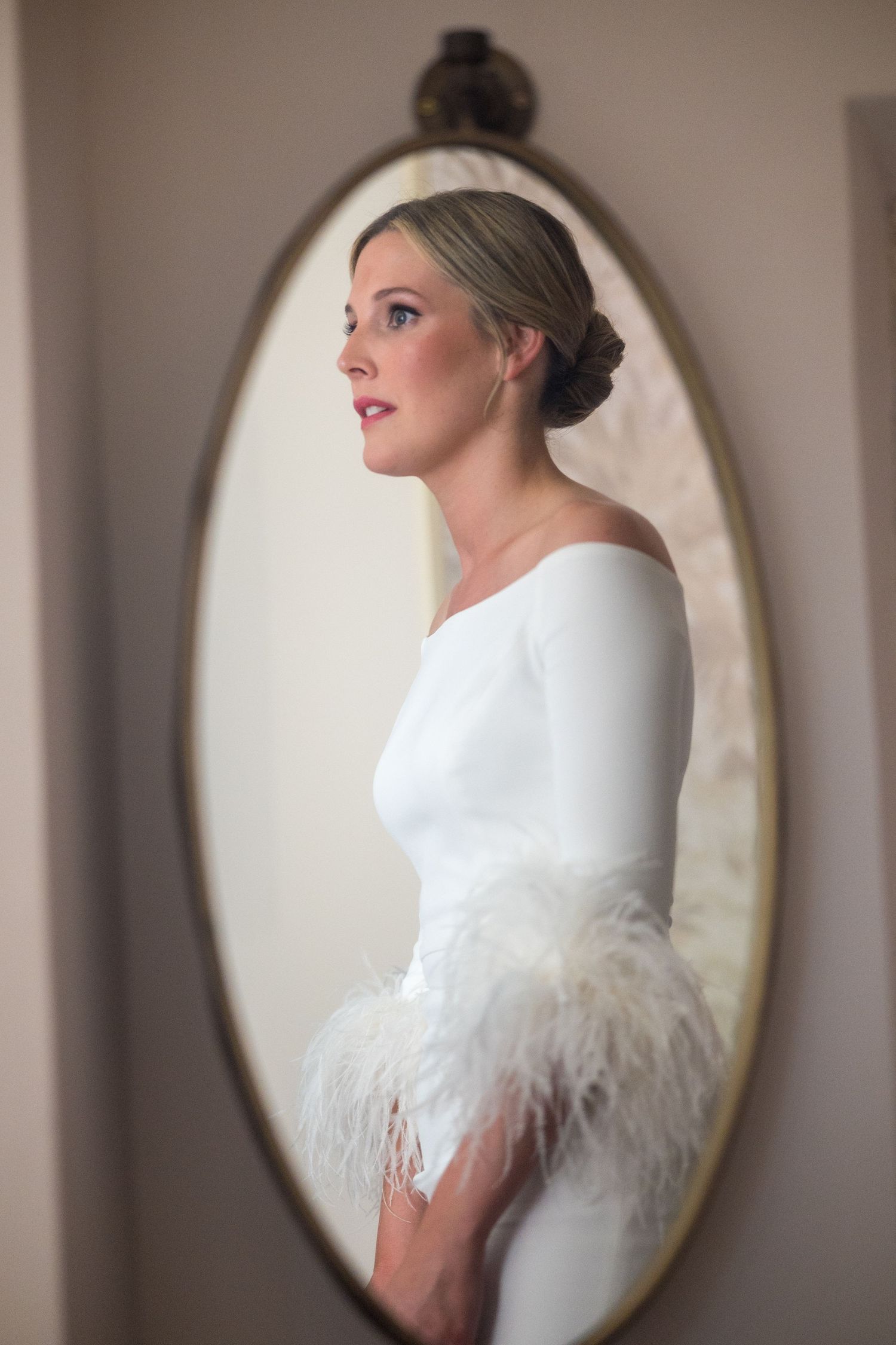 A series of five oval-framed portraits showing a bride in a white wedding dress with feathered details against a neutral backdrop.
