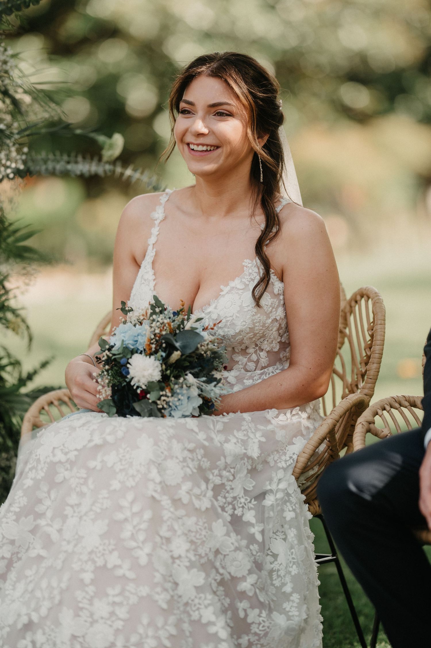 Close-up details of a white floral lace wedding dress with delicate embellishments.