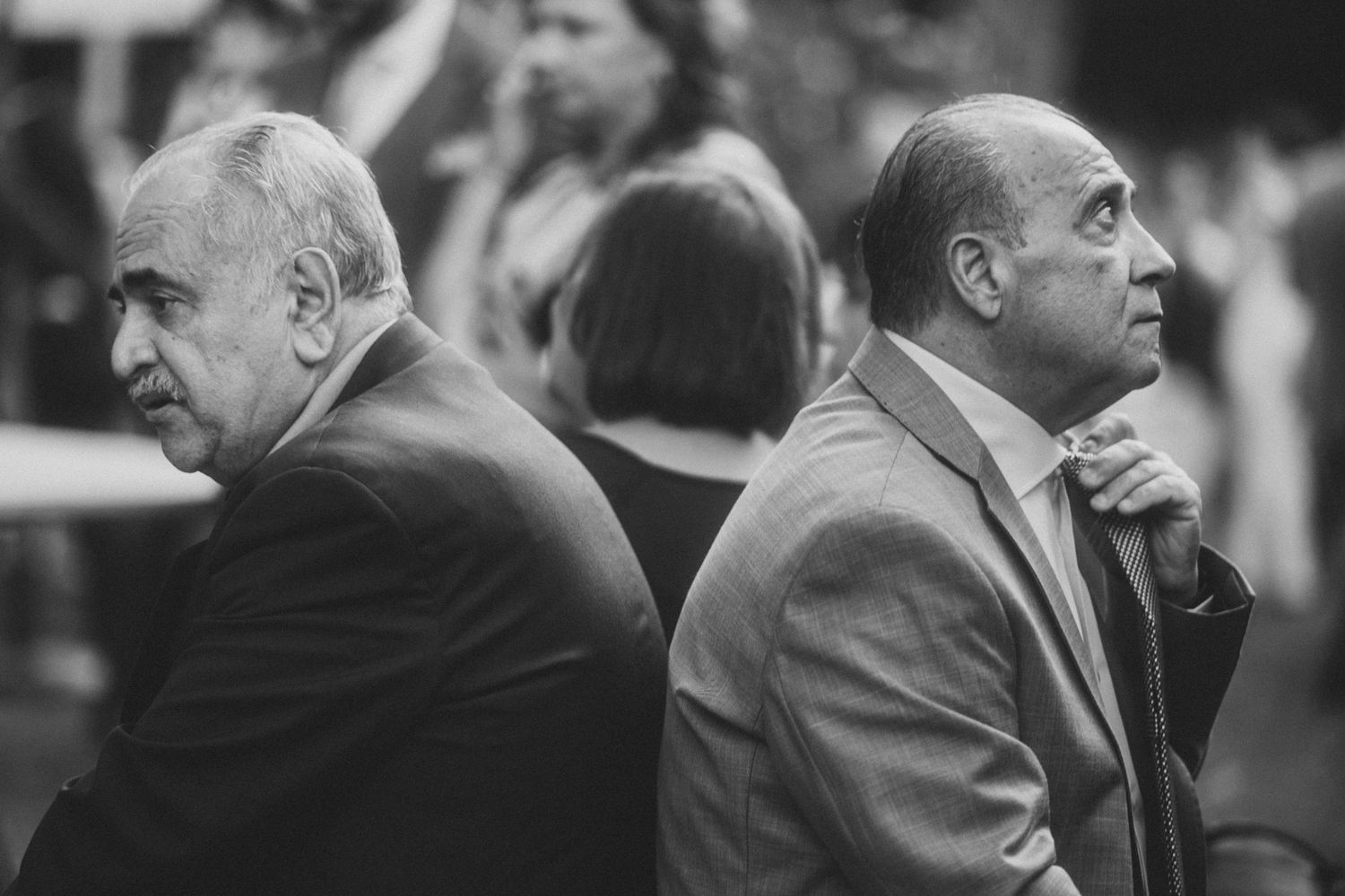 A black and white collage of people sitting in a row at what appears to be a formal event or ceremony.