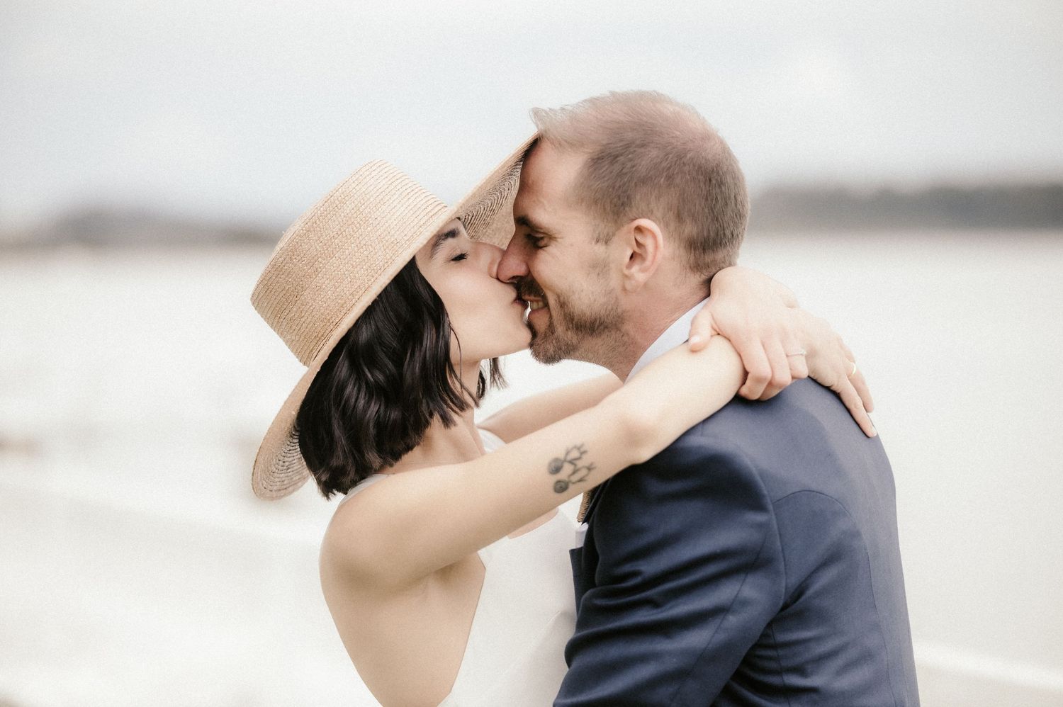 A romantic couple embraces and kisses in a series of intimate wedding photos outdoors.
