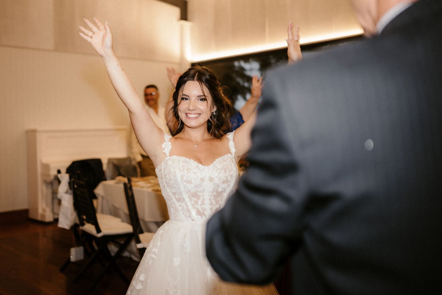 A bride and groom share their first dance together at their wedding reception in an elegant ballroom.