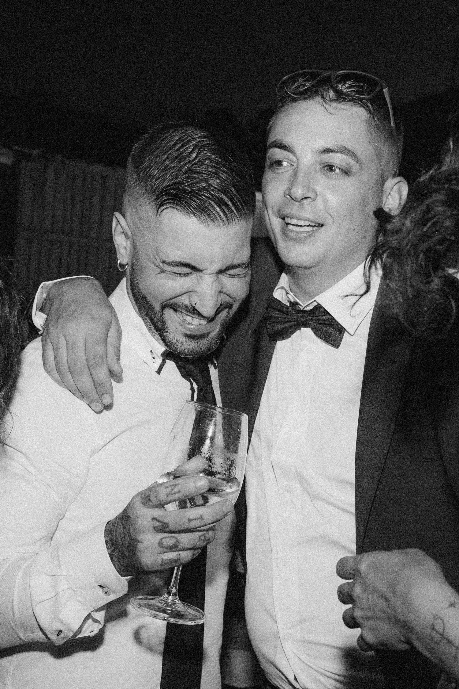 A sequence of black and white photos showing two people in white shirts sharing drinks and laughing together.