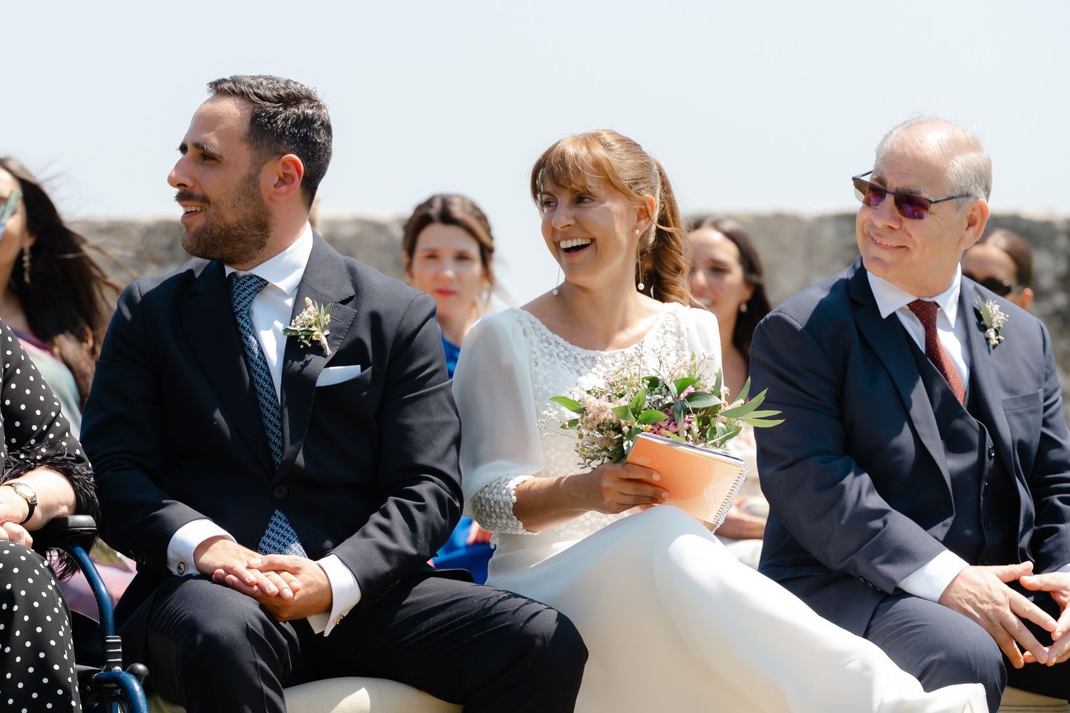 Wedding guests share joyful moments and laughter during an outdoor celebration.