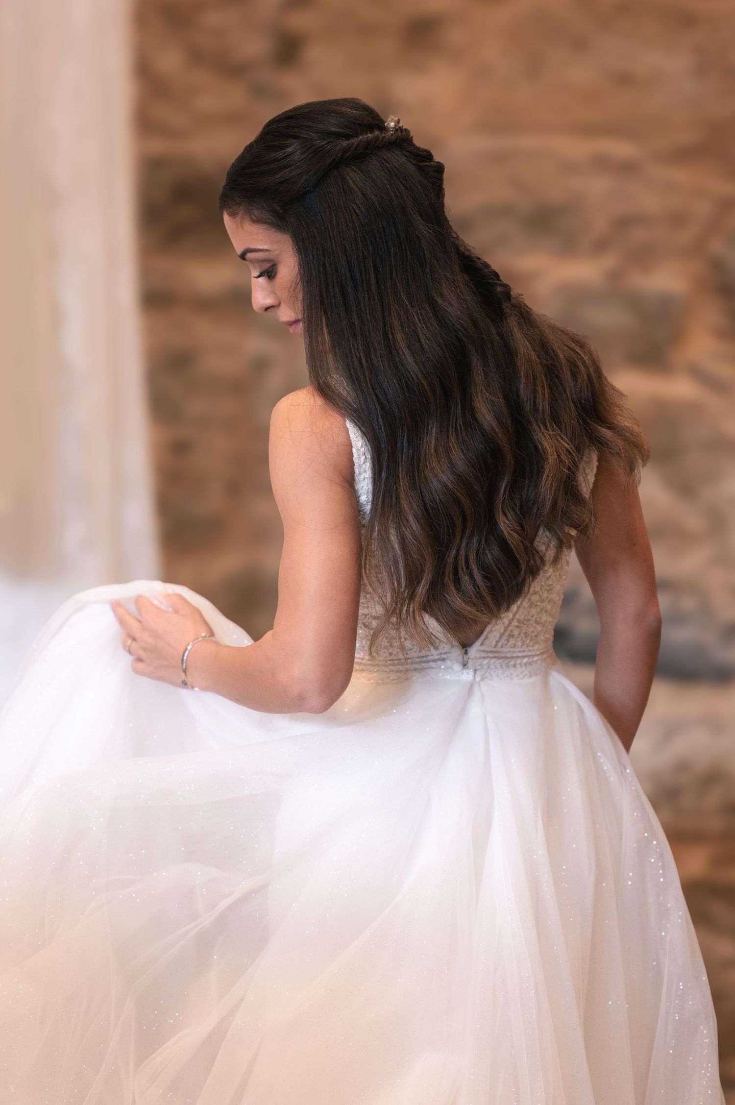 Back view of an elegant white tulle wedding gown with intricate lace bodice details.