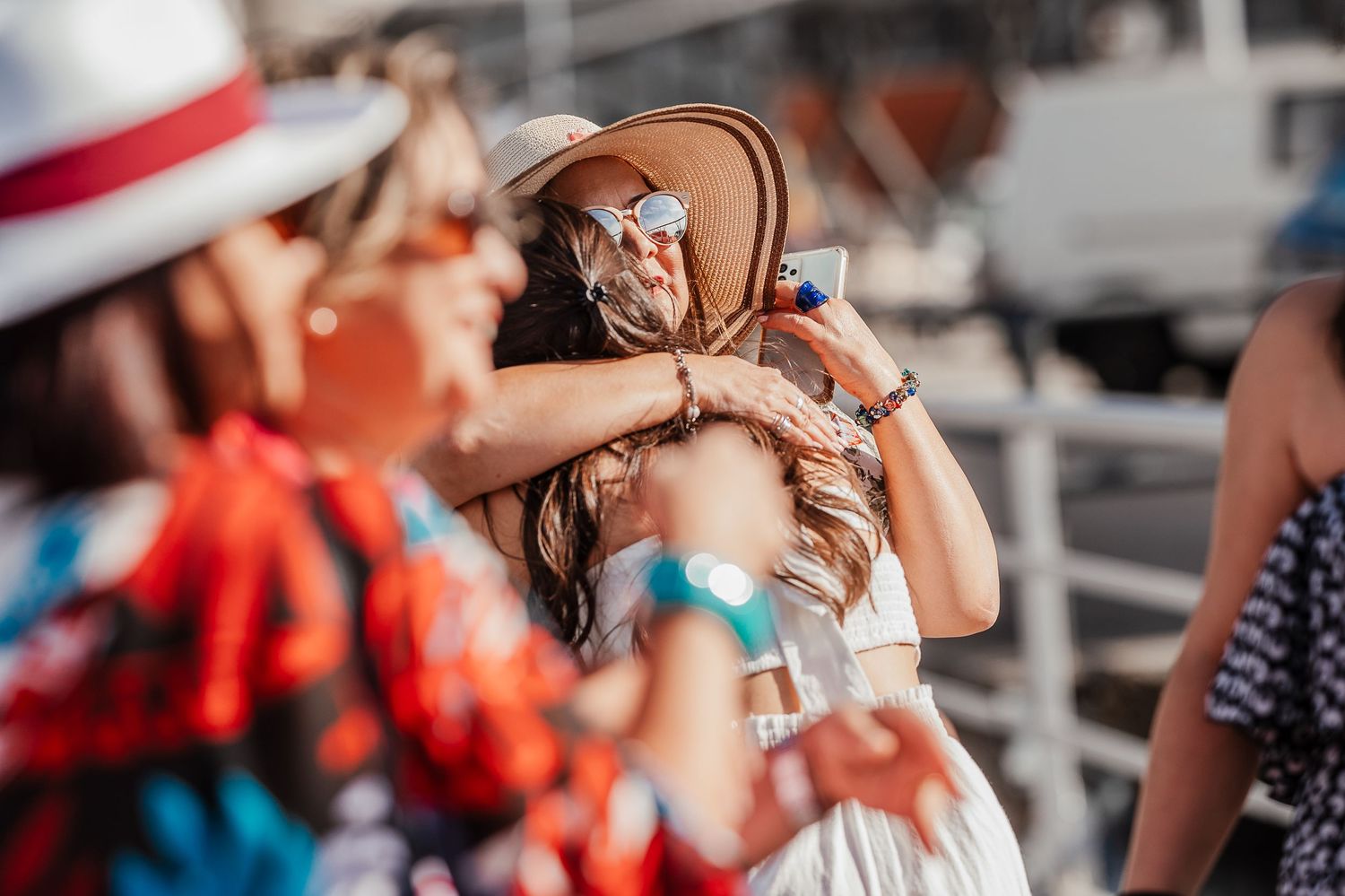People gathered at an outdoor celebration with festive decorations and bright sunlight.