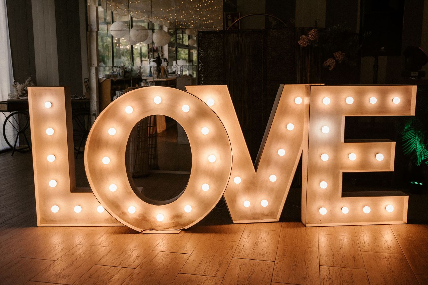 Illuminated LOVE marquee letters creating romantic ambiance against dark background.